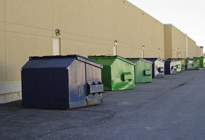 a construction worker empties a wheelbarrow of waste into the dumpster in Eustis